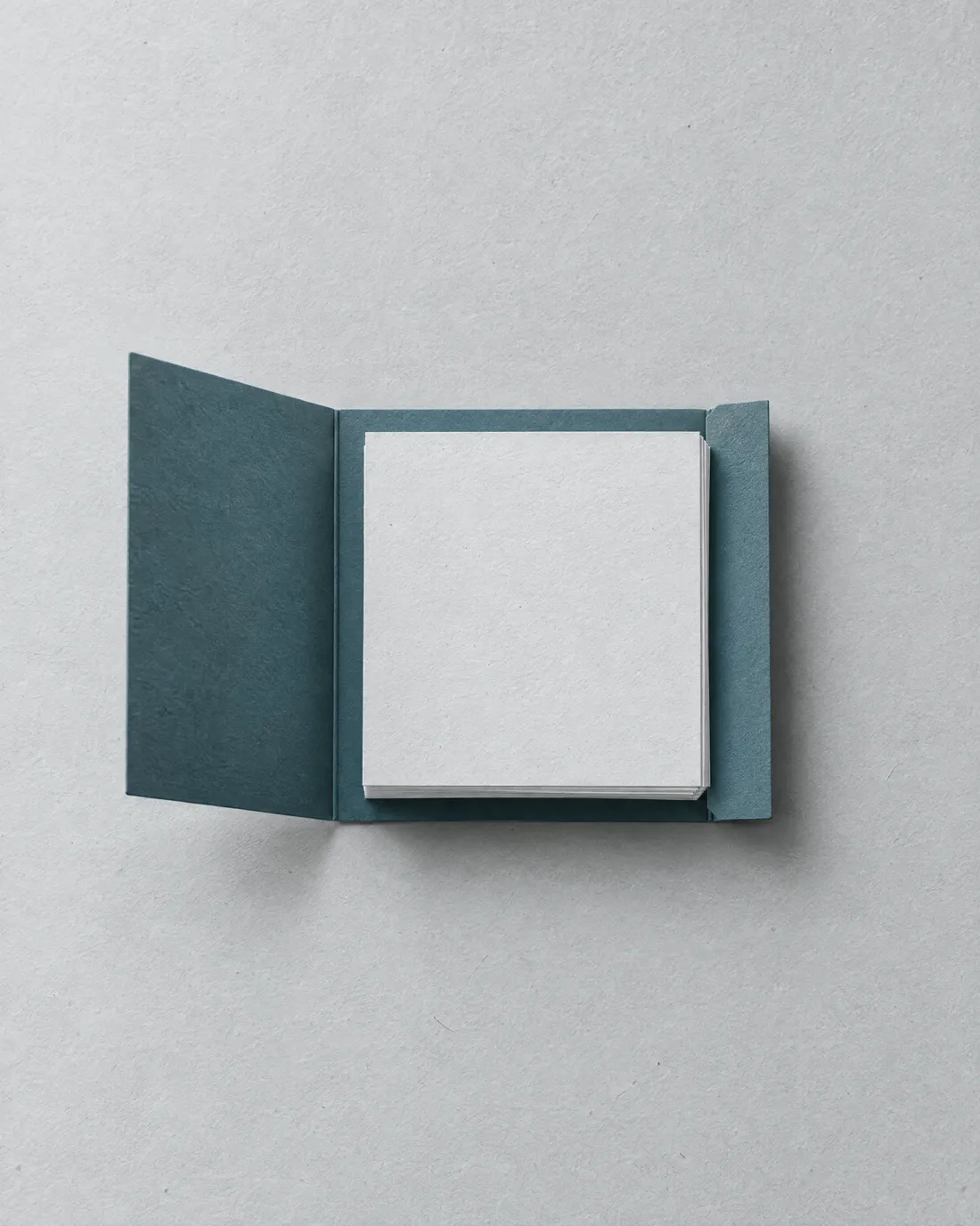 A neat stack of paper in an open blue folder.